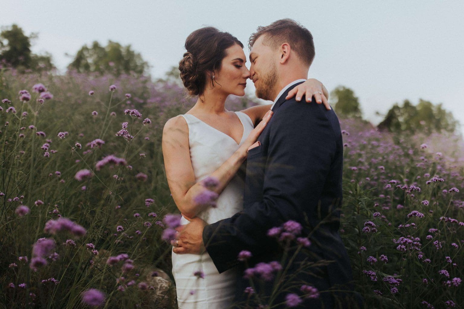 bride and broom in a field of purple wildflowers