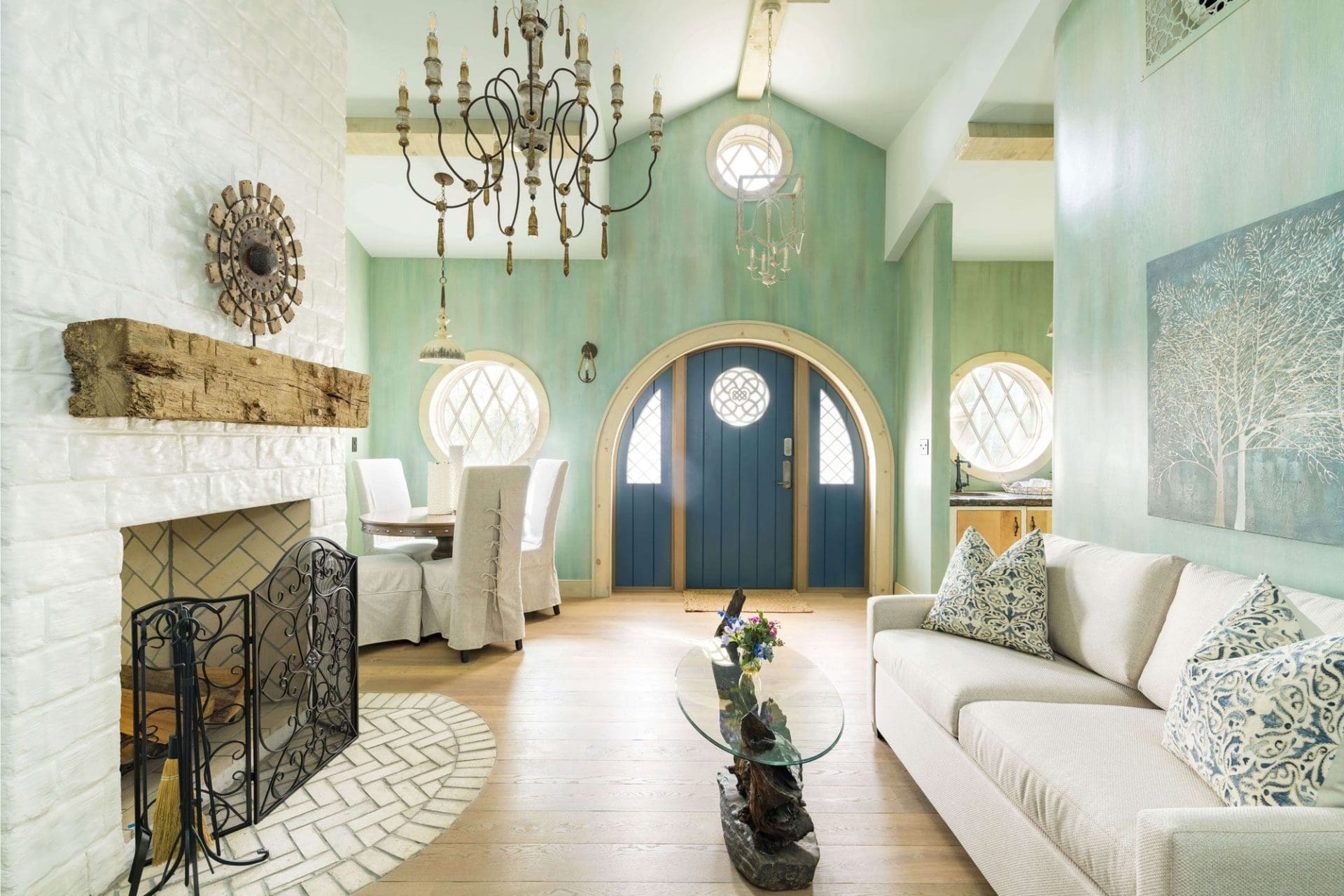 Outdoor wedding in a forest with seated guests watching the couple at the altar under a white arch decorated with flowers.