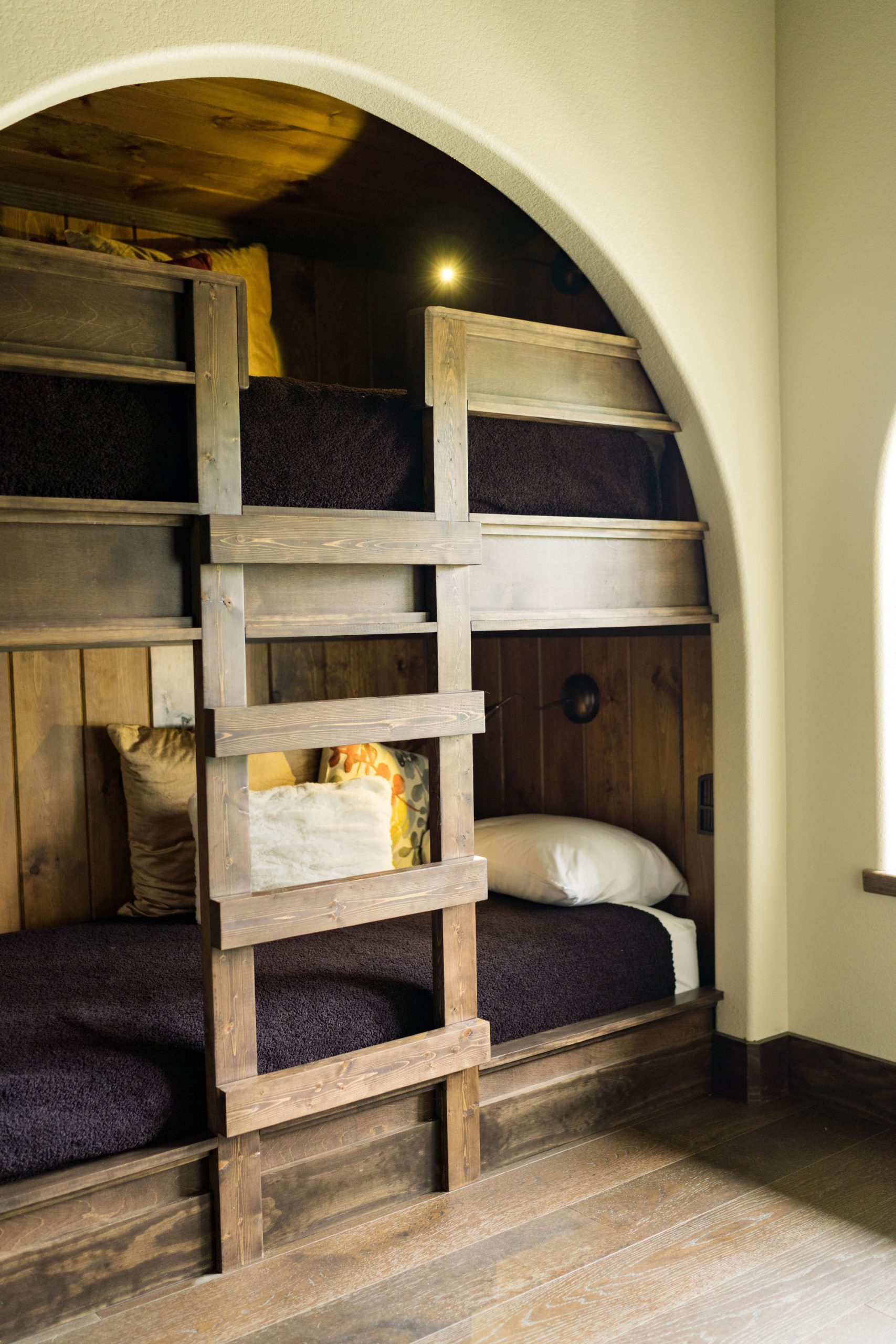 a bunk bed with a wooden ladder in a bungalow